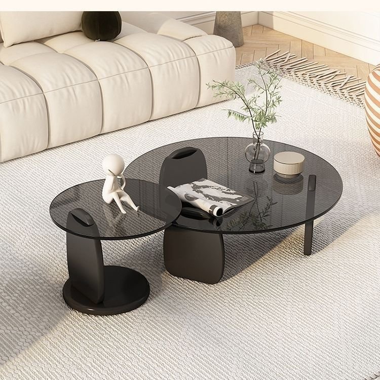 Sculptural smoked glass coffee table with attached side extension and modern black bases